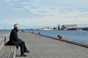 Man sitting alone by a waterfront in a peaceful moment, symbolizing emotional clarity and healing through anxiety counseling in Tulsa.