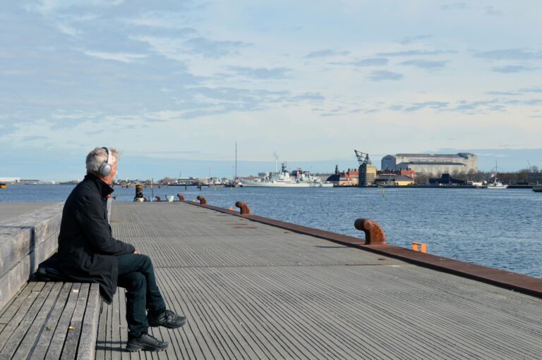 Man sitting alone by a waterfront in a peaceful moment, symbolizing emotional clarity and healing through anxiety counseling in Tulsa.